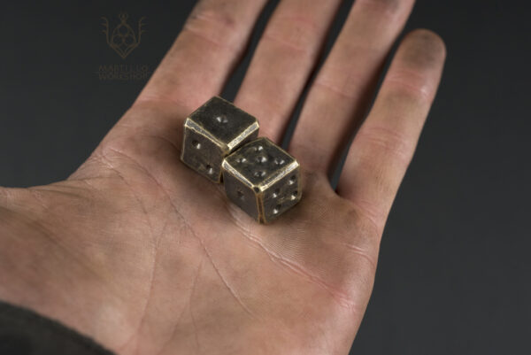2 brass dice in hand